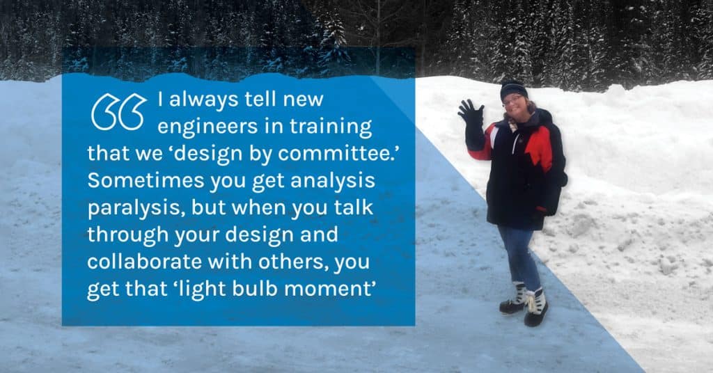 Drainage engineering expert Melinda Fischl waves at the camera. She is wearing heavy winter garments and standing in a snowy landscape with evergreen trees in the background.